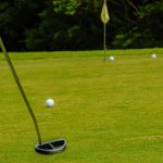 Golf ball on a green in front of the hole